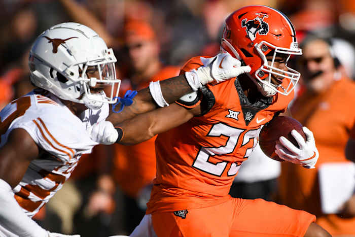 Texas defensive back Jahdae Barron attempts to stop Oklahoma State running back Jaden Nixon.